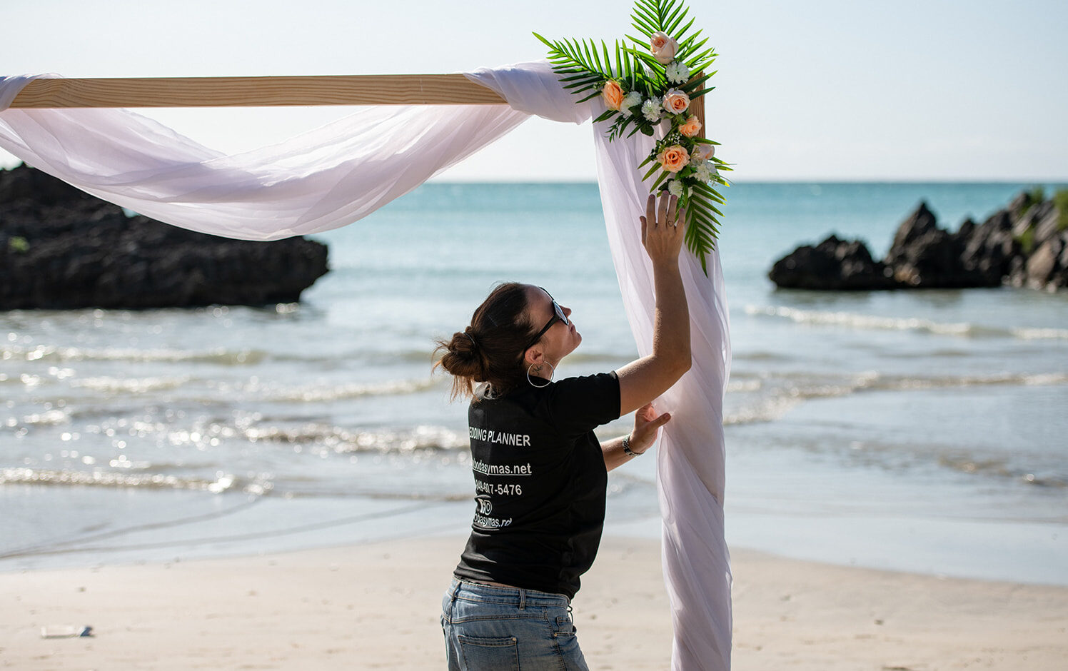 Wedding planner setting up a wedding arch.